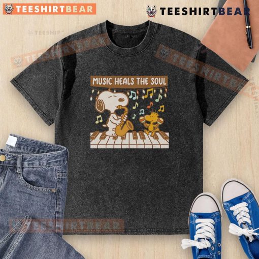 Top Snoopy and Woodstock piano music heals the soul washed t-shirt featuring playful cartoon design and vibrant colors.