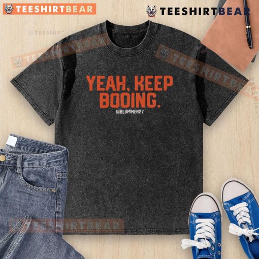 Top Yeah Keep Booing Ram Washed T-Shirt displayed on a hanger, showcasing its unique design and vibrant colors.