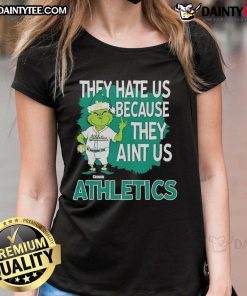 Alt Text: Awesome Athletics Grinch Christmas tee for ladies featuring 'They Hate Us Ain't Us' design in festive colors.