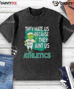 Alt Text: Awesome Athletics Grinch Christmas T-Shirt featuring 'They Hate Us Ain't Us' design for festive sports fans.
