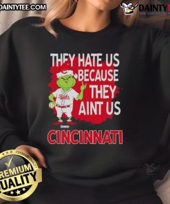 Alt Text: Awesome Cincinnati Reds Grinch Christmas sweatshirt featuring 'They Hate Us Ain't Us' design for festive fans.