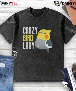 Cute crazy bird lady wearing a washed t-shirt featuring colorful bird prints, smiling in a sunny outdoor setting.