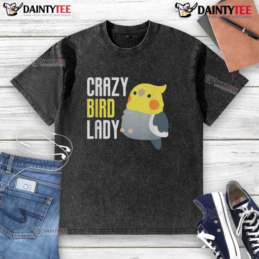 Cute crazy bird lady wearing a washed t-shirt featuring colorful bird prints, smiling in a sunny outdoor setting.