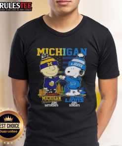 Alt Text: Cute Michigan Sports t-shirt featuring Charlie Brown Wolverines and Snoopy Detroit Lions with skyline design.