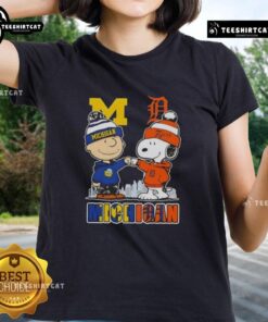 Cute Snoopy and Charlie Brown in Michigan sports gear, featuring Wolverines and Detroit Tigers skyline on ladies tee.