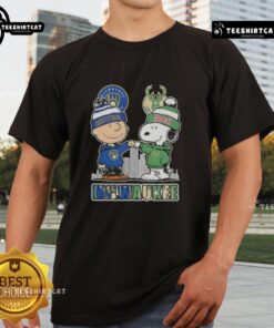 Alt Text: Cute Snoopy and Charlie Brown t-shirt featuring Milwaukee skyline with Brewers and Bucks logos.