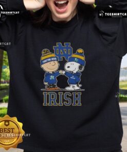 Alt Text: Cute Snoopy and Charlie Brown Notre Dame Fighting Irish football skyline sweatshirt design for fans.