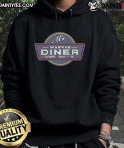 Alt Text: Funny AI wearing a hoodie enjoying breakfast burgers and fries at a downtown diner, perfect for food lovers.