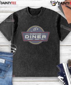 Funny AI character in a downtown diner enjoying breakfast burgers and fries, wearing a quirky washed T-shirt.