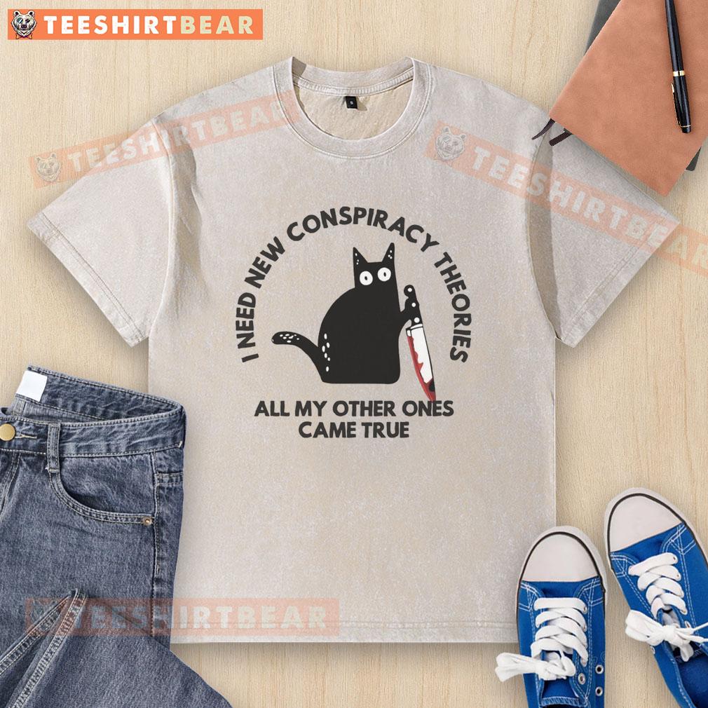Funny Cat I Need New Conspiracy Theories All My Other Ones Came True Washed T-Shirt Funny cat graphic on a washed t-shirt, captioned I Need New Conspiracy Theories All My Other Ones Came True.