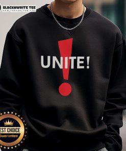 Alt Text: Dominic Fike humorously poses in a Unite sweatshirt, showcasing his unique style and playful personality.