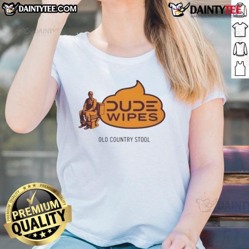 Alt Text: Humorous dude wipes an old country stool while wearing a ladies' tee, showcasing a funny and quirky moment.