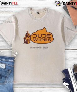 Funny dude wipes an old country stool while wearing a washed t-shirt, showcasing a humorous take on cleaning tasks.