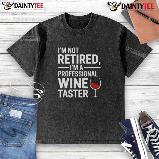 Funny 'I'm Not Retired, I'm A Professional Wine Taster' washed t-shirt displayed on a wooden background.