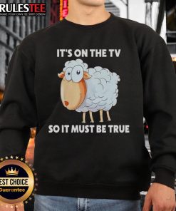 Funny sheep sweatshirt featuring 'It's on the TV, so it must be true' design, perfect for humorous apparel lovers.