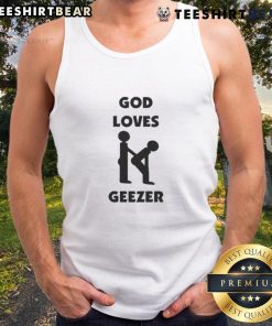 Alt Text: Dominic Fike wearing a 'God Loves Geezer' tank top, showcasing trendy streetwear style and vibrant colors.