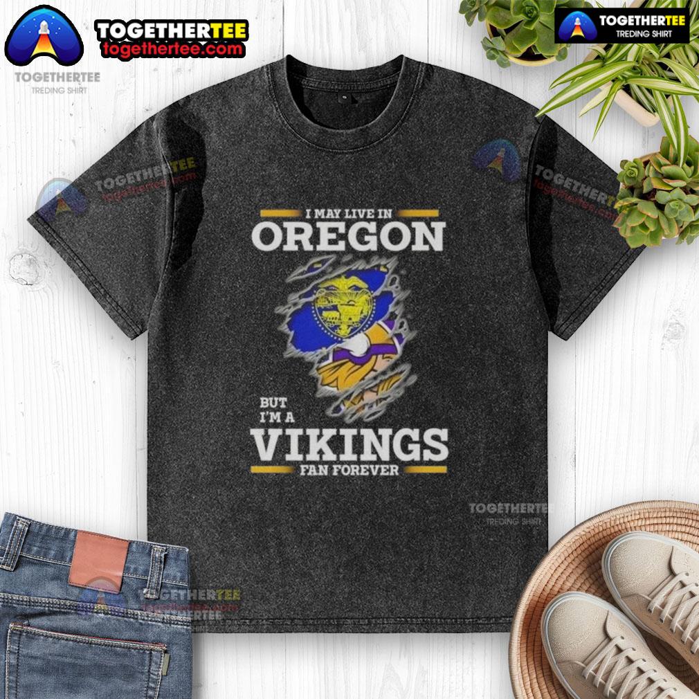 Good I May Live In Oregon But I'm A Minnesota Vikings Fan Forever Washed T-Shirt Alt Text: Good I May Live in Oregon but I'm a Minnesota Vikings Fan Forever washed t-shirt showcasing team pride.