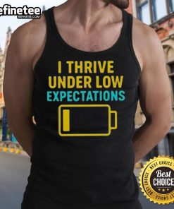 Model wearing a 'Good I Thrive Under Low Expectations' tank top, showcasing casual style and motivational message.