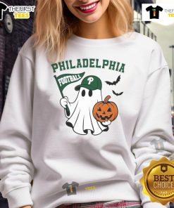 Alt Text: Good Philadelphia football ghost holding pumpkin and flag in Halloween sweatshirt, perfect for festive game day spirit.