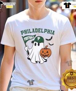 Good Philadelphia Football ghost holding a pumpkin and flag in Halloween T-shirt design for fans celebrating spooky season.