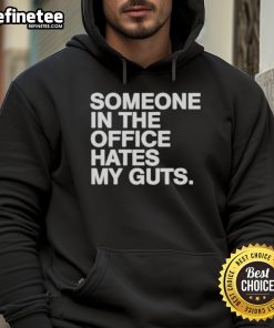 Good Someone In The Office Hates My Guts Hoodie displayed on a hanger, featuring a humorous graphic design in a modern office setting.