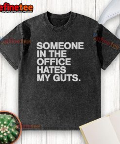 Good Someone In The Office Hates My Guts washed t-shirt displayed on a hanger in a modern office setting.