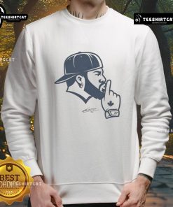 Vladimir Guerrero wearing a Toronto Blue Jays sweatshirt, showcasing his iconic 'Shush' gesture on the field.