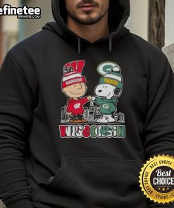 Alt Text: Happy Charlie Brown in Wisconsin Badgers x Snoopy hoodie with Green Bay Packers skyline, showcasing playful team spirit.