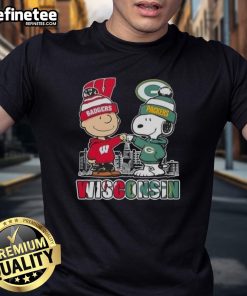 Alt Text: Happy Charlie Brown in Wisconsin Badgers and Snoopy with Green Bay Packers skyline on a stylish T-shirt.