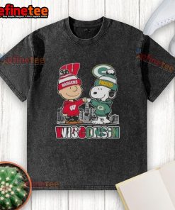 Alt Text: Happy Charlie Brown wearing Wisconsin Badgers x Snoopy t-shirt near Green Bay Packers skyline, perfect for fans.
