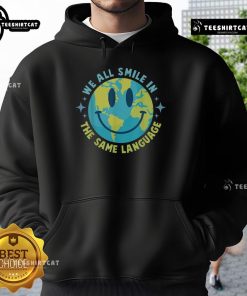 Alt Text: Happy Earth We All Smile In The Same Language hoodie featuring a vibrant design promoting global unity and positivity.