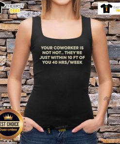 Person wearing 'Hot, Your Coworker Is Not Hot' tank top, laughing at a desk in a casual office environment.