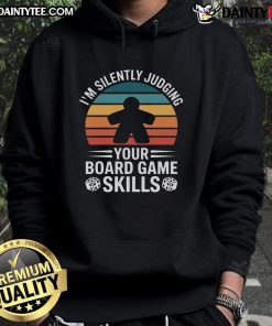 Adults enjoying a fun game night in cozy hoodies, playing board games and sharing laughter together.