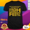 T-shirt featuring 'Nice I Got My Human Rights Violated At The Riyadh Comedy Festival' slogan in bold print.