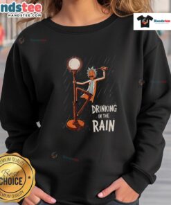 Rick from Rick and Morty wearing a sweatshirt, enjoying a drink in the rain, showcasing the Nice Rick Drinking design.