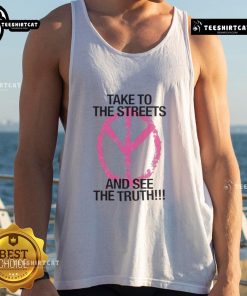 Stylish 'Take To The Streets and See The Truth' tank top displayed on a model against a vibrant urban backdrop.