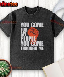 Alt Text: Nice You Come For My People You Come Through Me washed t-shirt displayed on a hanger in a trendy clothing store.