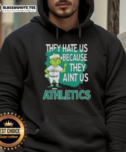 Official Athletics Grinch Christmas hoodie featuring 'They Hate Us Ain't Us' design for festive sports fans.