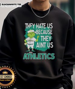 Official Athletics Grinch Christmas sweatshirt featuring 'They Hate Us Ain't Us' design for festive sports fans.