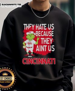 Official Cincinnati Reds Grinch Christmas sweatshirt, featuring a playful design with 'They Hate Us Ain't Us' slogan.