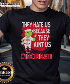 Alt Text: Official Cincinnati Reds Grinch Christmas T-shirt featuring 'They Hate Us Ain't Us' design for festive fans.