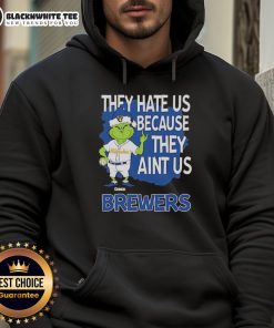 Official Milwaukee Brewers Grinch Christmas hoodie featuring 'They Hate Us Ain't Us' design, perfect for holiday fans.