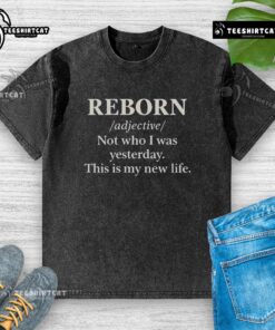Official Reborn 'Not Who I Was Yesterday, This Is My New Life' washed t-shirt displayed on a wooden background.