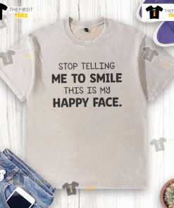 Alt Text: Official Stop Telling Me To Smile This Is My Happy Face washed t-shirt displayed on a hanger, showcasing its casual style.