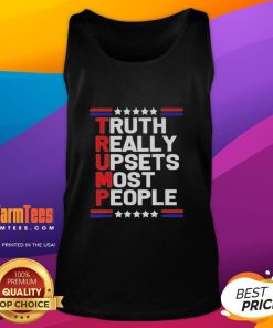Charlie Kirk wearing a tank top with 'Official Truth' slogan, highlighting the divisive views on Trump.