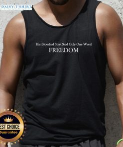 Alt Text: Charlie Kirk wearing a bloodied shirt with the word Freedom, showcasing his message on a tank top.