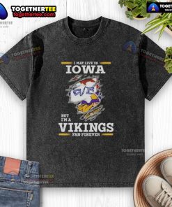 Premium washed t-shirt saying 'I May Live in Iowa But I'm a Minnesota Vikings Fan Forever' for dedicated fans.