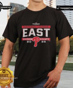 Premium Philadelphia Phillies MLB 2025 NL East Division Title T-Shirt in locker room setting, celebrating postseason success.