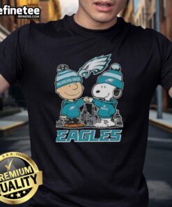 Alt Text: Premium Snoopy and Charlie Brown Philadelphia Eagles football skyline T-shirt featuring iconic characters and team logo.