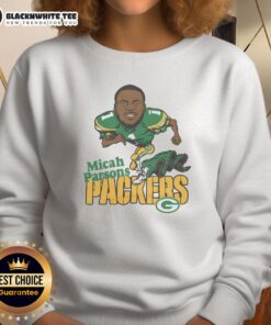Alt Text: Micah Parsons wearing a stylish green sweatshirt supporting the Green Bay Packers at a game.